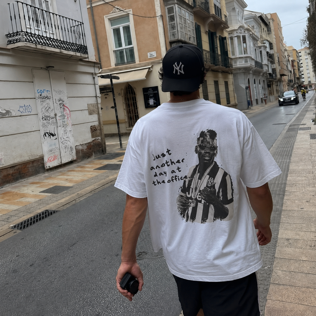 Model wearing the Day At The Office tee walking through the streets