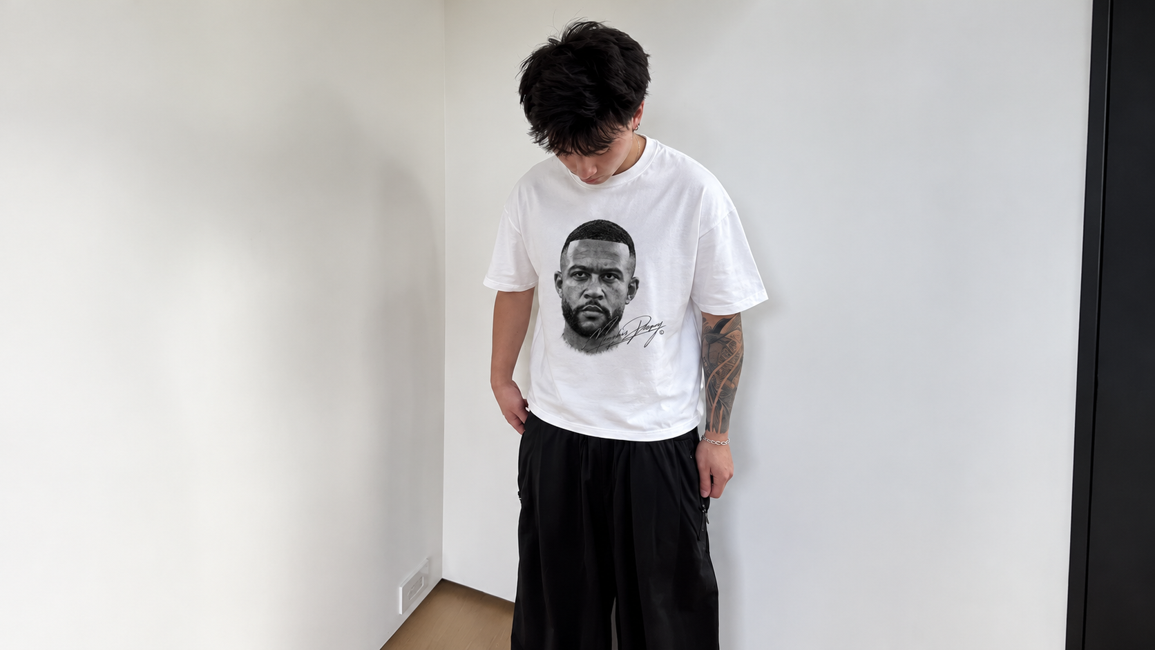 Model in a white room wearing a JØGA front portrait tee