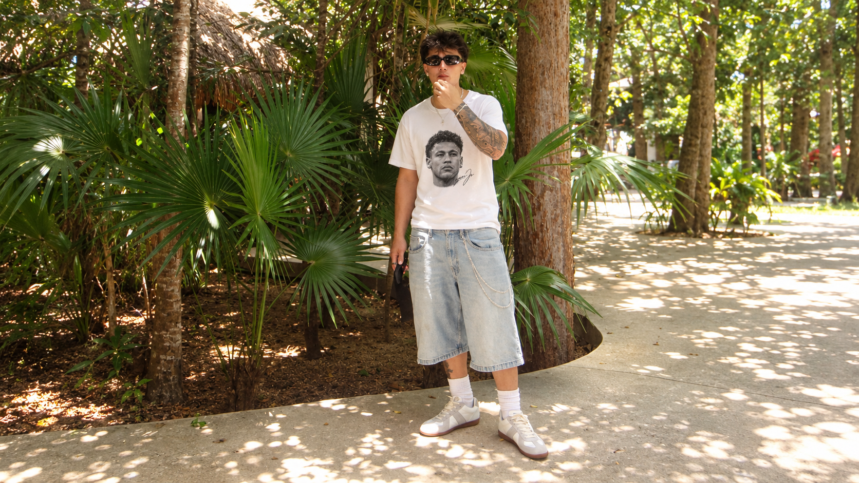 Model between palm trees wearing a JØGA front portrait tee