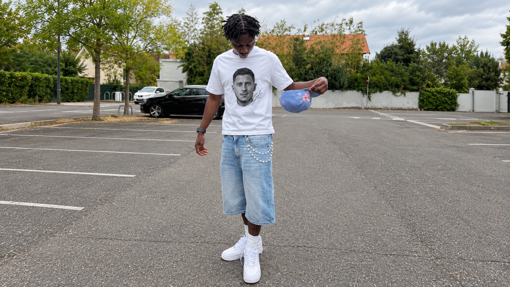 Model in a parking lot with a ball wearing a JØGA front portrait tee