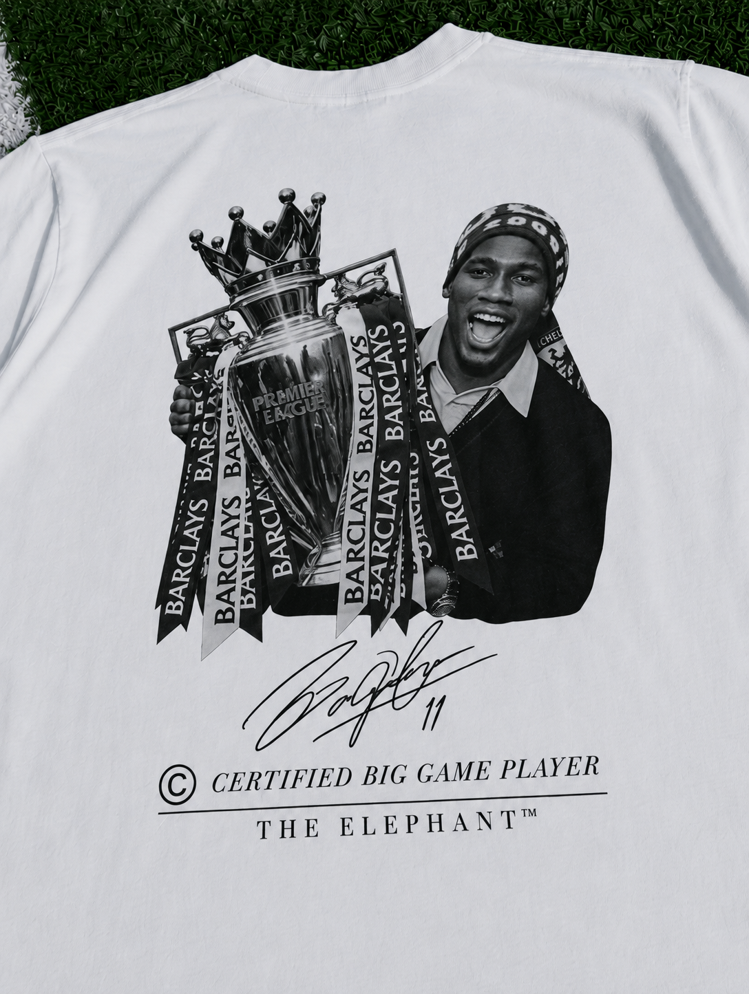 White heavyweight organic cotton T-shirt featuring a Didier Drogba-inspired football graphic with trophy artwork zoomed in